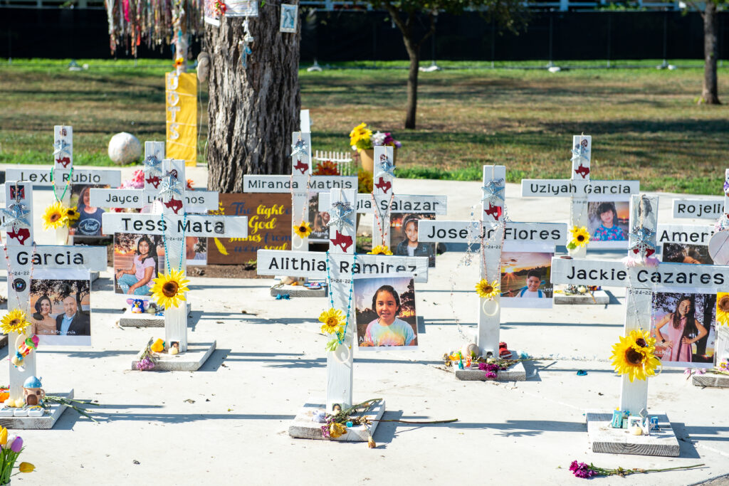 A photo of small white crosses bearing the names and photos of the students and teachers killed in the Uvalde School shooting.