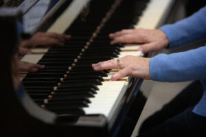 A closeup of hands on a piano