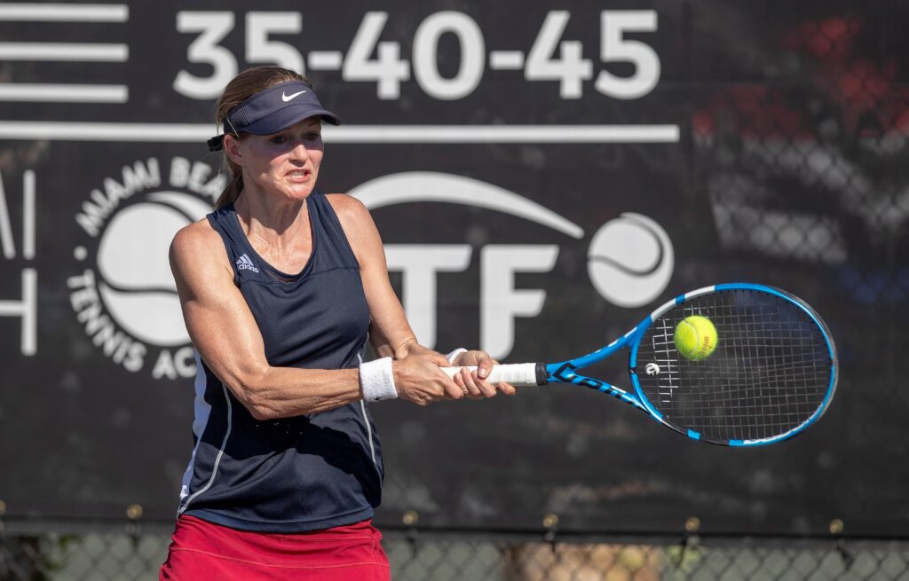 An action shot of Thu hitting a tennis ball.