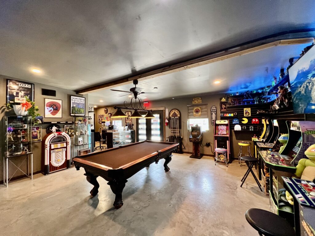 A photo of the museum's game room shows a large space with arcade games and a pool table.