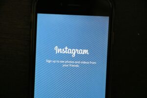 A blue phone screen that reads "Instagram. Sign up to see photos and videos from your friends" in white.